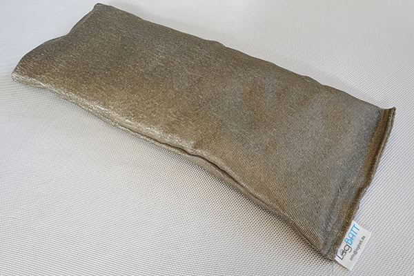 En brun stofpude ligger pÄ en hvid overflade.